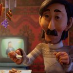 Animação mostra um homem de expressão séria sentado à mesa, segurando uma colher pequena. Ele tem cabelos pretos lisos, bigode espesso e veste suéter de tricô cinza. Ao fundo, há uma televisão desfocada ligada e uma tapeçaria vermelha decorando a parede.