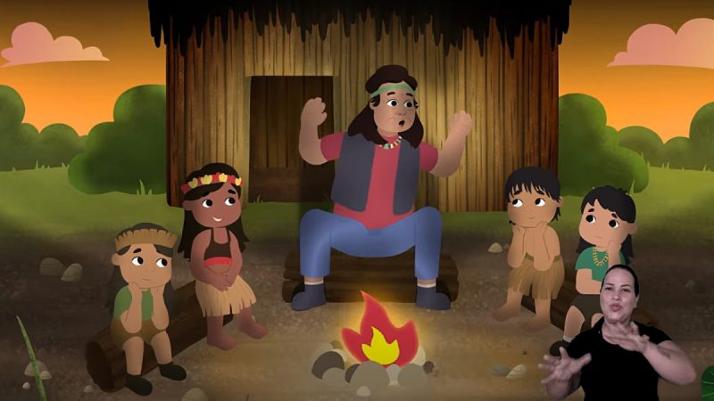 Ilustração mostra personagem contando histórias ao redor de uma fogueira para quatro crianças indígenas diante de uma oca, com intérprete de Libras no canto inferior direito.