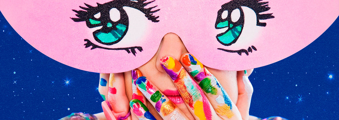 Máscara rosa com olhos desenhados em estilo de quadrinhos cobre o rosto; mãos à frente pintadas com cores vibrantes do arco-íris em fundo azul estrelado.