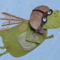 Animação em colagem mostra criatura verde alada, com casco e grandes dentes, voando contra o céu azul.