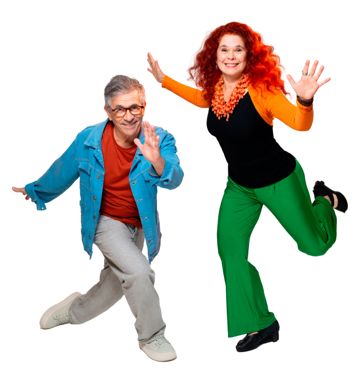 Fotografia em fundo branco: um homem grisalho, de óculos e jaqueta azul, e uma mulher ruiva, com blusa preta e calça verde, posam sorridentes em movimentos de dança, com os braços erguidos. Eles são Paulo Tatit e Sandra Peres, a dupla "Palavra Cantada".